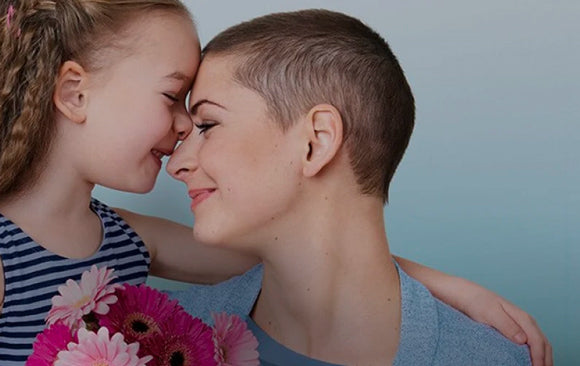 Une mère et sa fille souriantes face à face