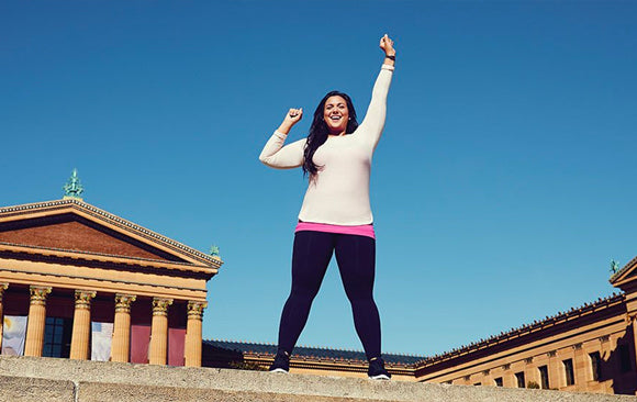 Une femme debout, les bras en l’air, pointant le ciel